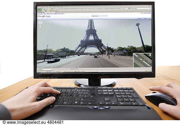 Person sitzt am Computer  arbeitet mit Google Street View  Über Google Maps  im Internet  Ansicht von Pariser Straßen  Eiffelturm  Deutschland