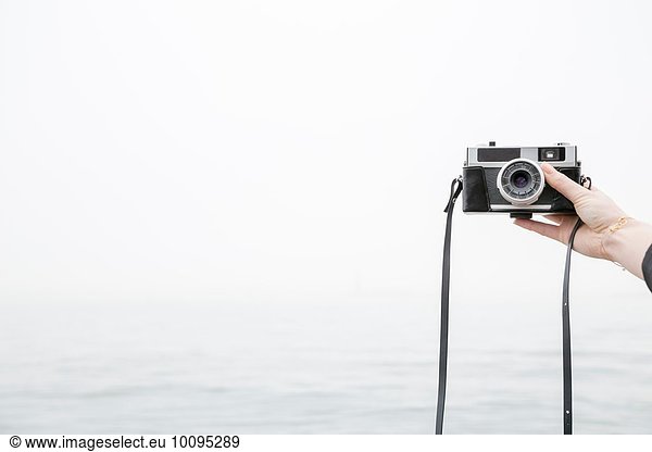 Person taking selfie with camera  sea in background