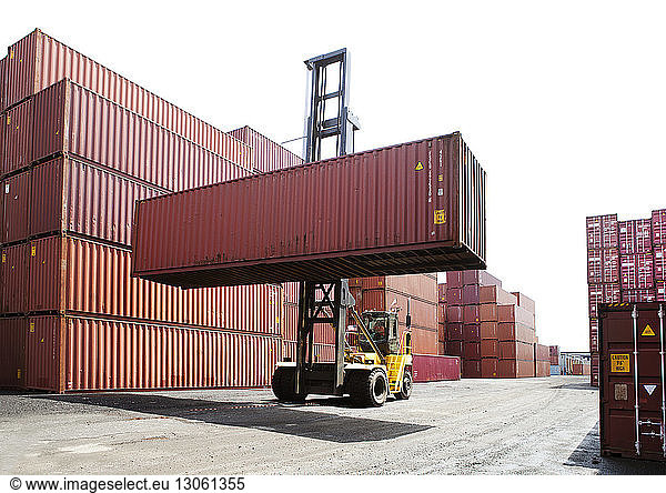 Person transporting cargo container from forklift in commercial dock