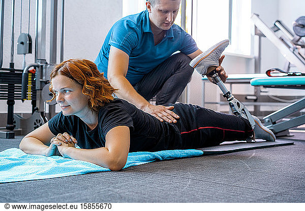 Personal trainer assisting woman with disabilities in her workout