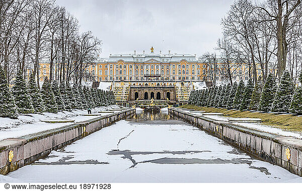 Peterhof Baroque summer palace  the facade o fthe buildings and the Grand Cascade in the gardens  a water pool and golden fountains  in winter.
