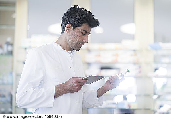 pharmacist in a pharmacy with a tablet