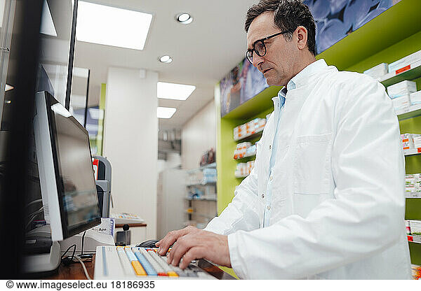 Pharmacist using desktop PC in store