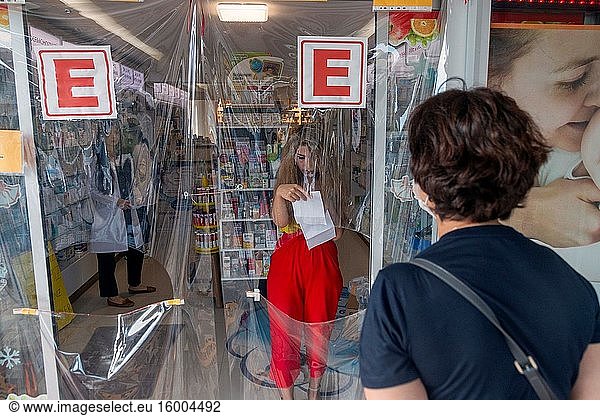 Pharmacists serve customers behind protective plastic at a pharmacy in Ankara  Turkey  on June 4  2020. Turkey's total COVID-19 cases increased to 167 410 on Thursday  with 988 new cases.