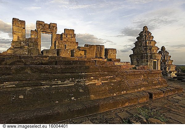 Phnom Bakheng Temple. Sunrise. The construction of this temple mountain on Phnom Bakheng (Bakheng Hill) the first major temple to be constructed in the Angkor area marked the move of the capital of the Khmer empire from Roluos to Angkor in the late 9th century AD. It served as King Yasovarman I's state-temple at the center of his new capital city Yasodharapura. The foundation of Bakheng is carved from the existing rock edifice rather than the laterite and earthfill of most other temples. Bakheng's hilltop location makes it the most popular sunset location in the area offering a view of the Tonle Sap Lake and a distant Angkor Wat Temple in the jungle. (A good photo of Angkor Wat in the distance requires at least a 400mm lens. ) The temple is usually overcrowded at sunset sometimes even completely overrun by tourists. Due to overuse and damage the main stairway up the mountain has been closed and an alternate path to the top has been opened. Elephant Ride sup and down the hill are also available from about 4:00PM till sunset. $15/person up the mountain. $10 per person down the mountain.