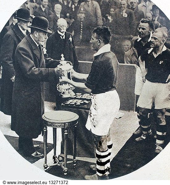 Photograph of His Majesty King George V presenting the F.A. Cup to the Captain of Manchester City at Wembley Stadium