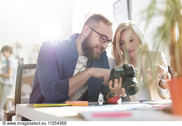 Photographer design professionals using SLR camera in office