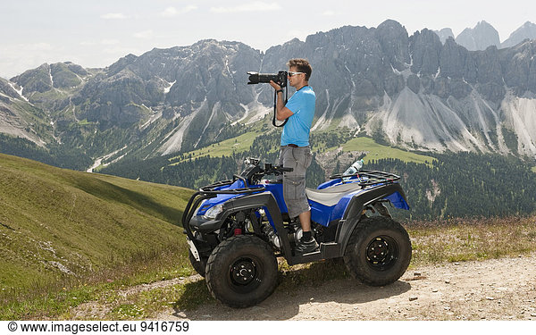 Photographer in mountain landscape Quad bike