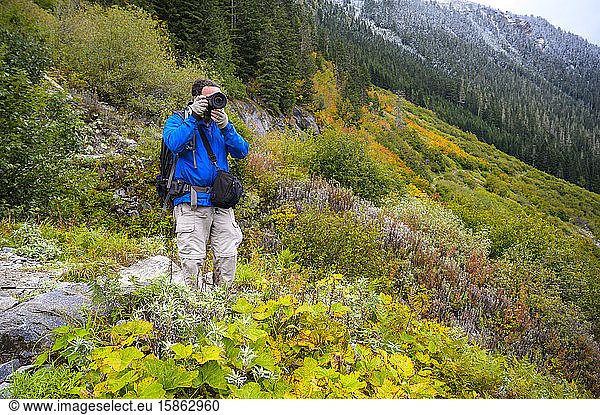 Photographer on hiking trail with blue jacket