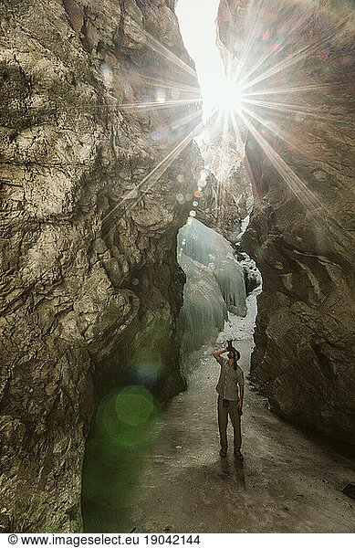 photographer shoots photos up into a frozen ice cave