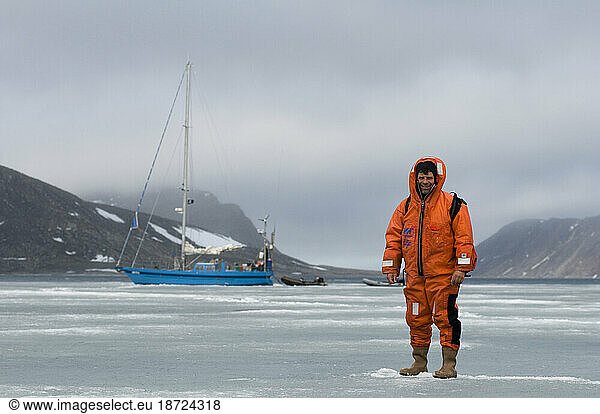 Photographer Steven Kazlowski  in a survival suit  stands and poses for a photo on fjord ice  during an expedition to photograph polar bears in Svalbard  Norway.