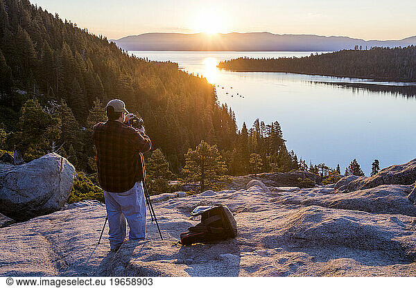 Photographer taking pictures of sunrise at Emerald Bay in Lake Tahoe  California  USA