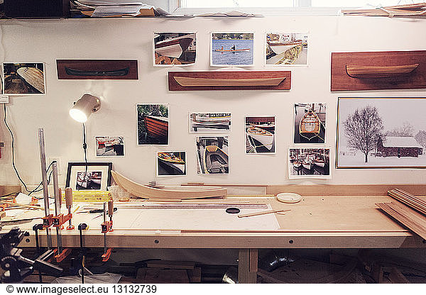 Photographs of boats stuck on wall in workshop