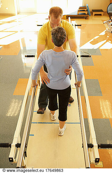 Physical therapist with patient in gym