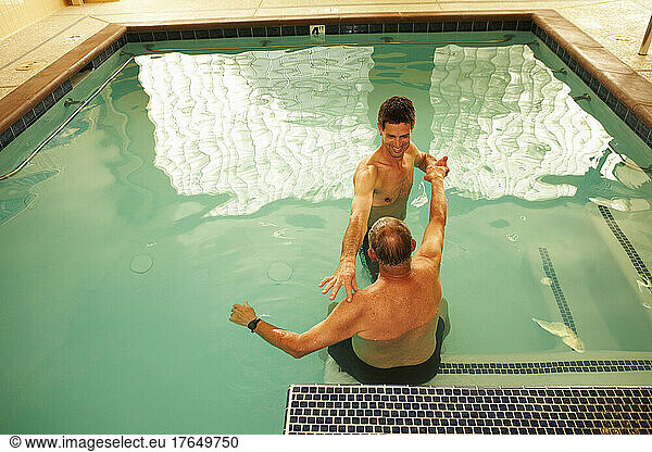 Physical therapist working with patient in swimming pool