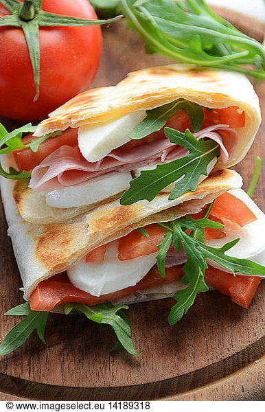 Piadina italian flatbread with  tomato  mozzarella cheese  rucola salad  ham  Emilia Romagna  Italy  Europe