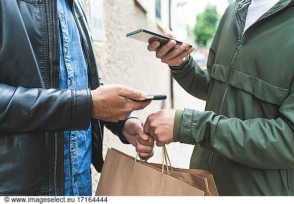 Picking up takeaway  using contactless payment on phones