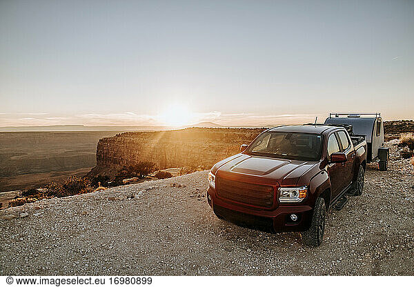 Pickup-Truck und Wohnmobil auf einem Campingplatz in der Wüste von Utah bei Sonnenuntergang