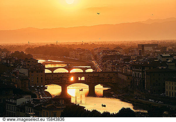 Picturesque cityscape with bridges over river at golden sunshine