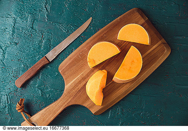 pieces of pumpkin cut on a wooden board