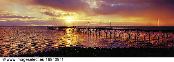 Pier im Meer mit Sonnenuntergang am Horizont des Ozeans.