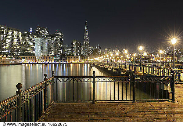 Pier 7 with illuminated building in background at San Francisco  California  USA