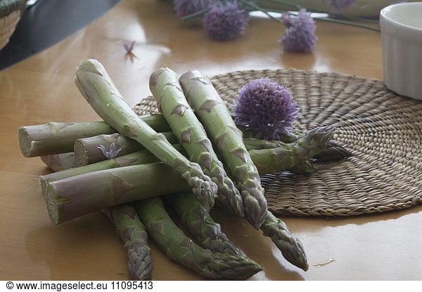 Pile of asparagus with flower on table