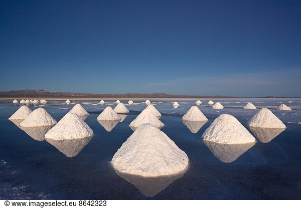 Piles of salt dry in the arid atmosphere of Bolivia's Salar de Uyuni.