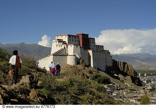 Pilger und Touristengruppe vor wiederaufgebauter Festung Shigatse Dzong  mit tibetischer Altstadt von Shigatse  Zentraltibet  Tibet  China  Asien