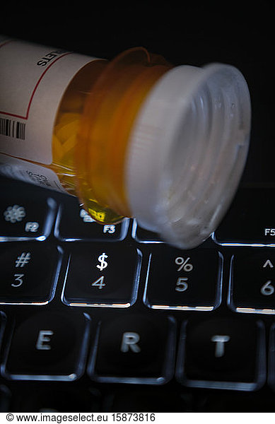 Pill bottle on computer keyboard