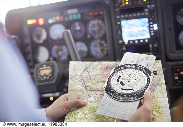 Pilot checking navigational map and compass instrument in airplane cockpit