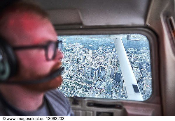 Pilot fliegt Flugzeug über Stadtlandschaft