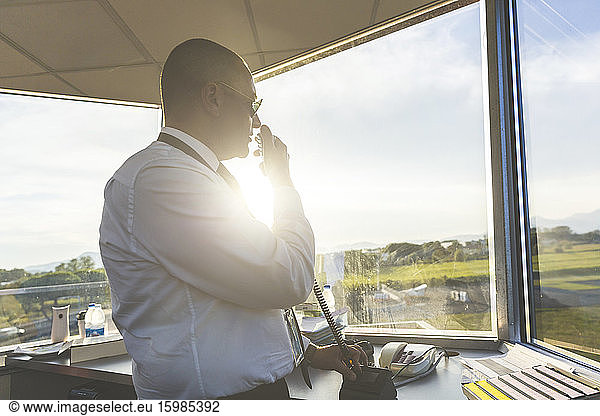 Pilot standing in control tower  talking on the radio