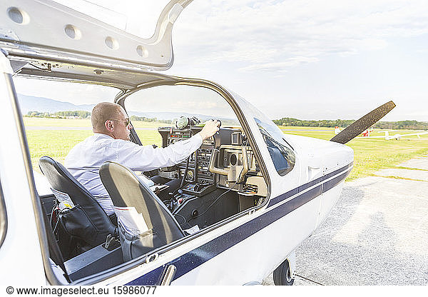 Pilot with headset  sitting in sports plane