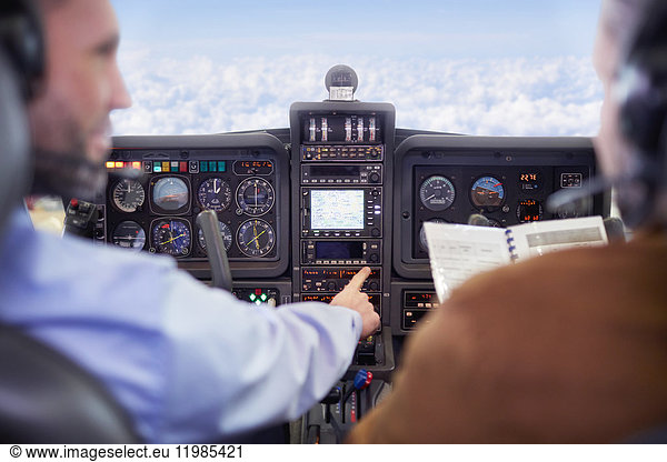 Pilots flying airplane in cockpit