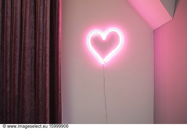 Pink Heart neon light on wall in a modern interior  retro design Valentines concept close-up.