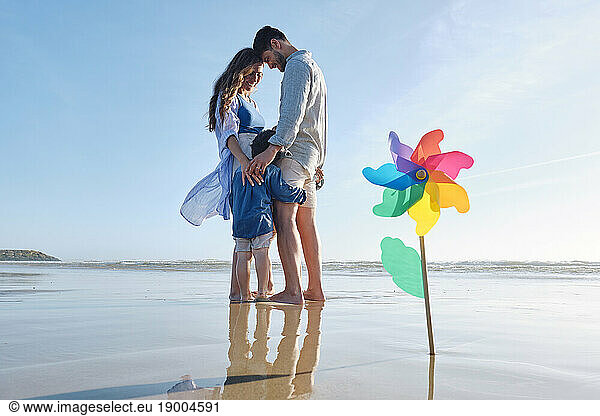 Pinwheel toy at beach with family standing together in background