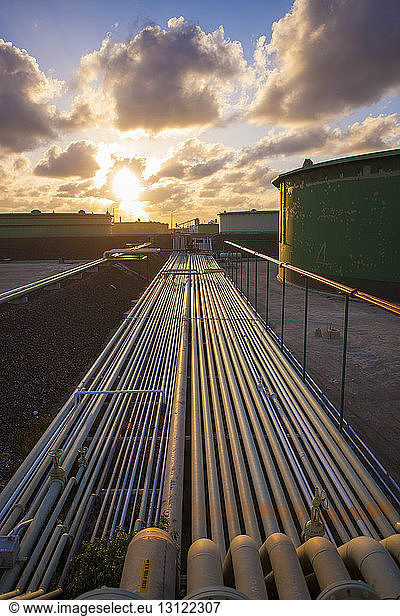 Pipelines in der Industrie gegen bewölkten Himmel bei Sonnenuntergang