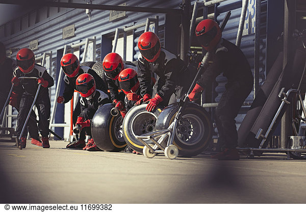 Pit crew preparing tires in formula one pit lane