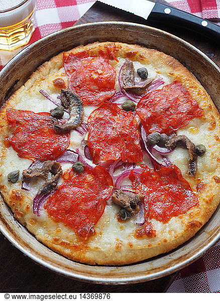 Pizza with mozzarella cheese  italian hot salami  cappers  Tropea red onions and anchovies  Milan  Italy  Europe