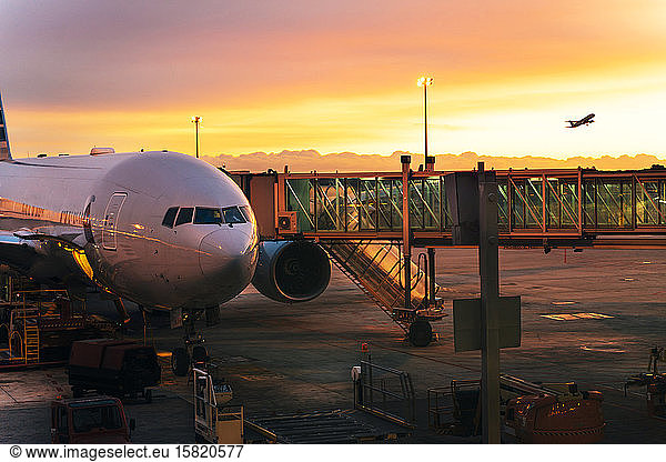 Plane taking off to the sky and a plane ready to board in  airport at sunrise in Barcelona  Spain