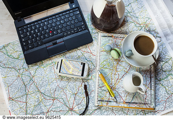 Planning a journey with maps  cell phone and coffee