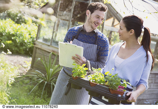 Plant nursery owners with clipboard and potted plants