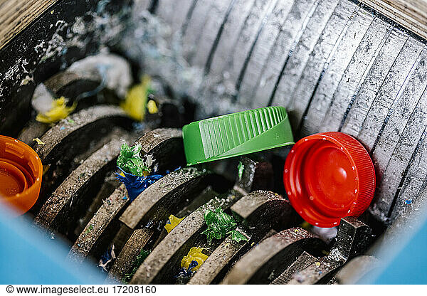 Plastic bottle caps being recycled in machinery