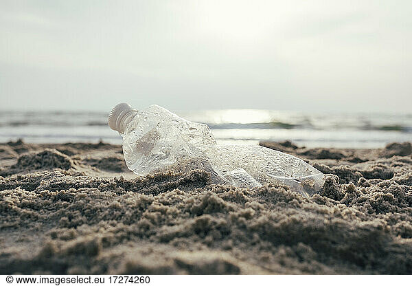 Plastic water bottle on sand at beach