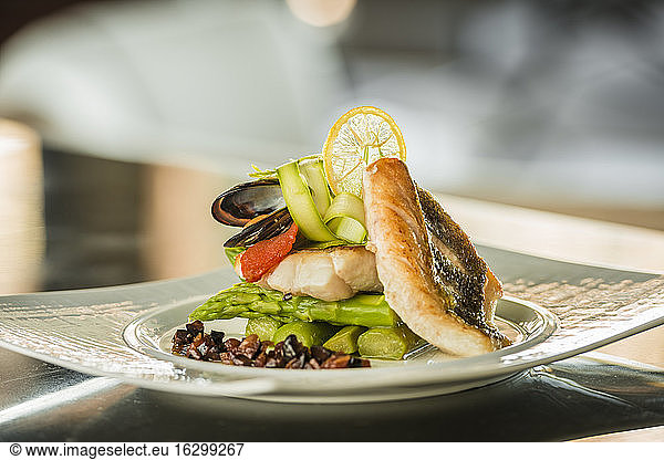 Plate of sea bass with green asparagus and blue mussel
