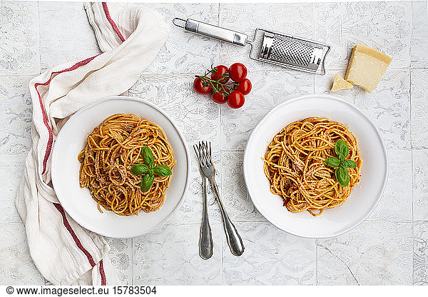 Plates of spaghetti with tomato sauce  Parmesan cheese and basil