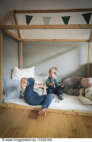 Playful brothers laughing in bedroom at home