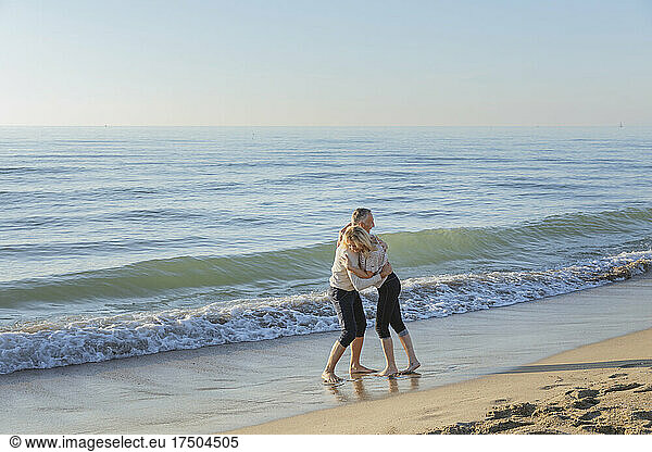 Playful couple enjoying near seashore at beach