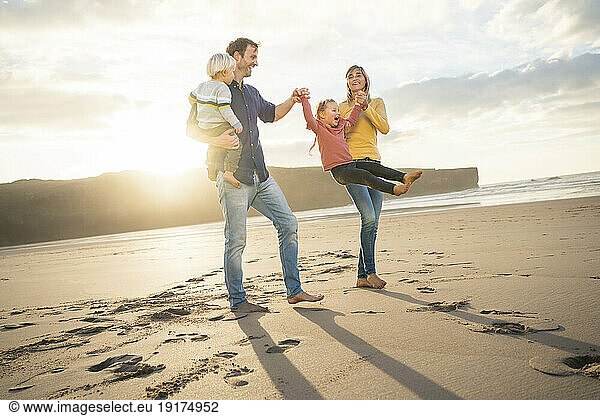 Playful family having fun with children at beach